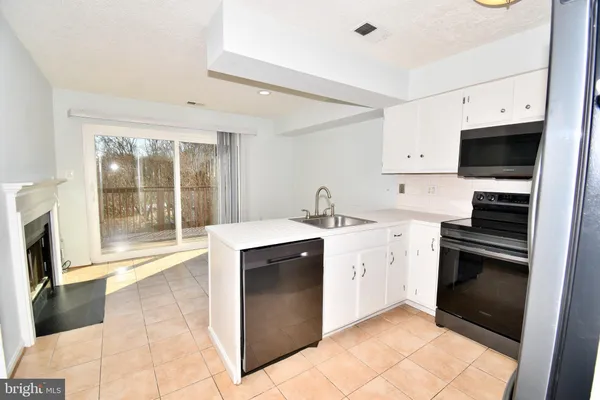 a kitchen with a refrigerator and a fireplace