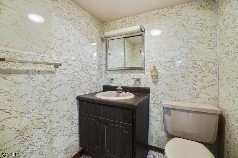 11 North Derby Road Springfield, NJ 07081 - Photo 15 of 30 a bathroom with a granite countertop toilet sink and mirror