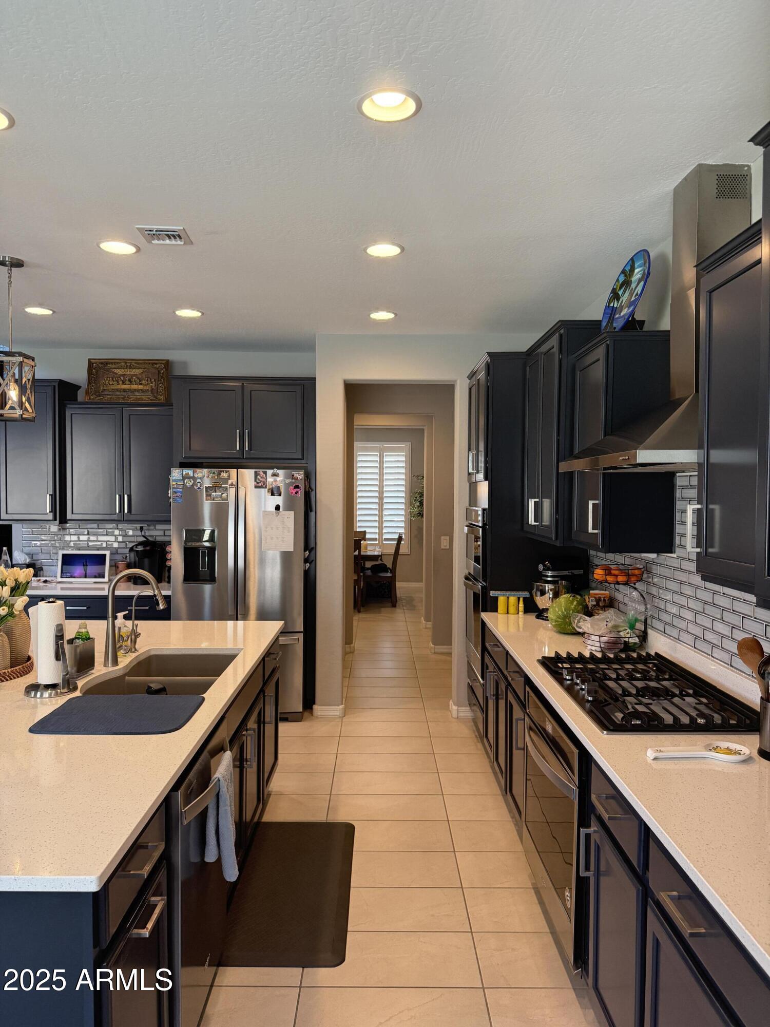 6980 West Redbird Road Peoria, AZ 85383 - Photo 7 of 31 a kitchen with stainless steel appliances granite countertop a sink stove and refrigerator