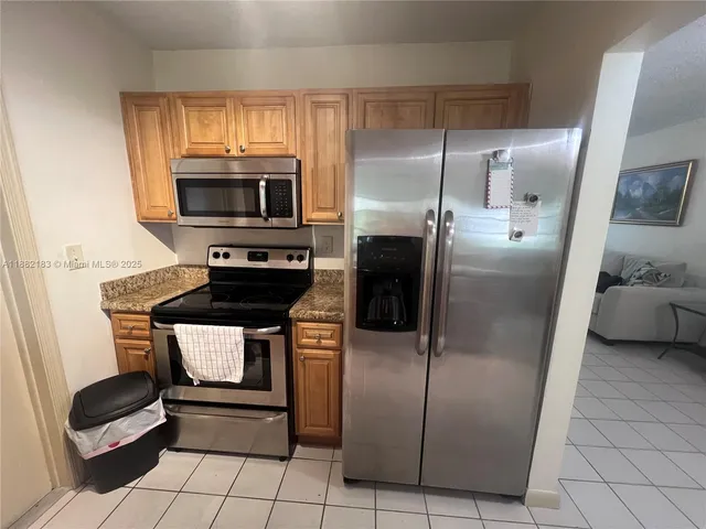 a kitchen with stainless steel appliances granite countertop a refrigerator and a stove