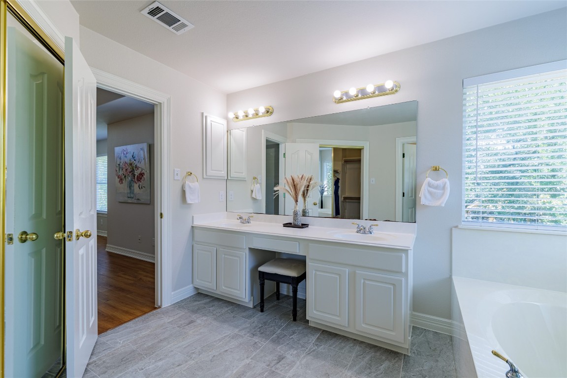 205 Ridge Run Court Georgetown, TX 78628 - Photo 29 of 40 a spacious bathroom with a double vanity sink a large mirror and a bathtub