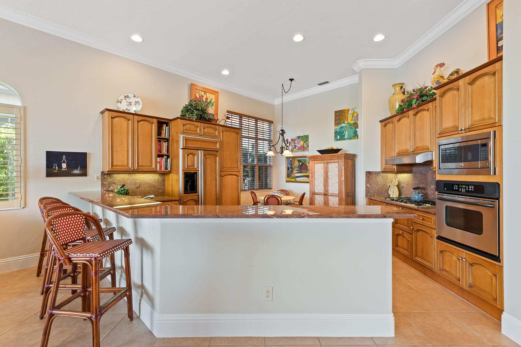 8528 Bellagio Drive Naples, FL 34114 - Photo 4 of 50 a kitchen with stainless steel appliances granite countertop a refrigerator and a stove top oven with wooden floor