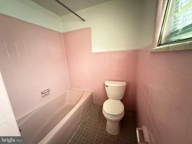 a bathroom with a toilet and a bathtub