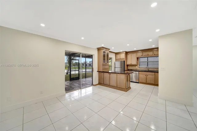 a kitchen with stainless steel appliances granite countertop a sink a stove and cabinets