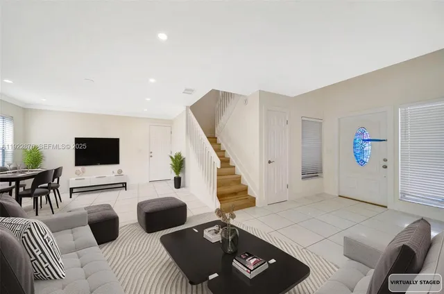 a spacious bedroom with a bed a couch and a potted plant on the dresser