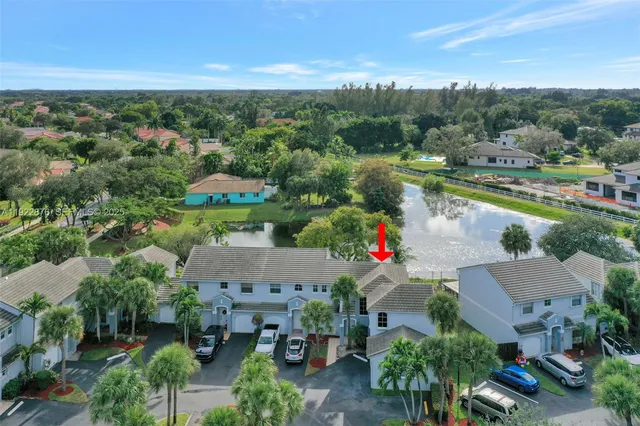 an aerial view of residential houses with outdoor space and lake view