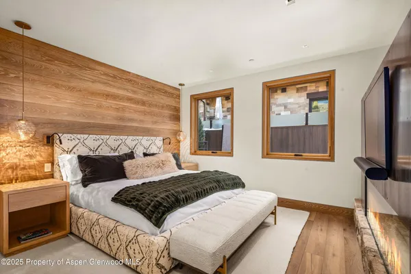 a bedroom with a bed a mirror on dresser and a window
