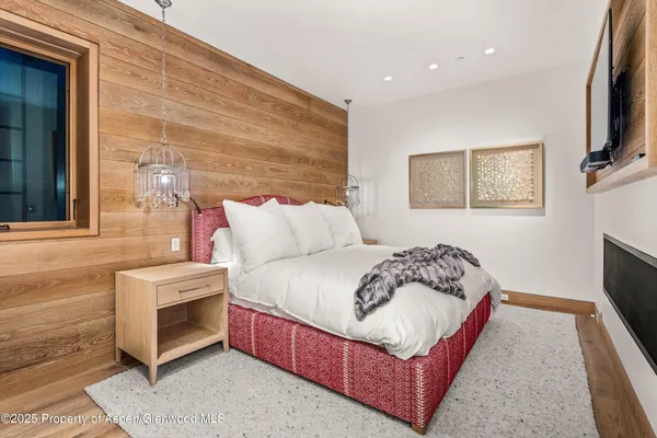 a bedroom with a bed and a flat screen tv