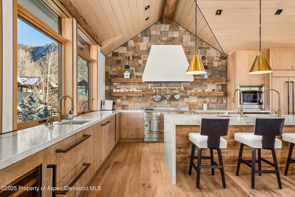 a kitchen with stainless steel appliances granite countertop a sink and wooden cabinets