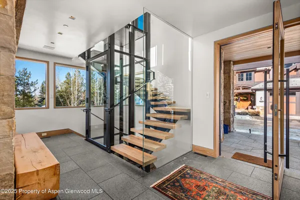 a view of entryway with a floor to ceiling window and stairs