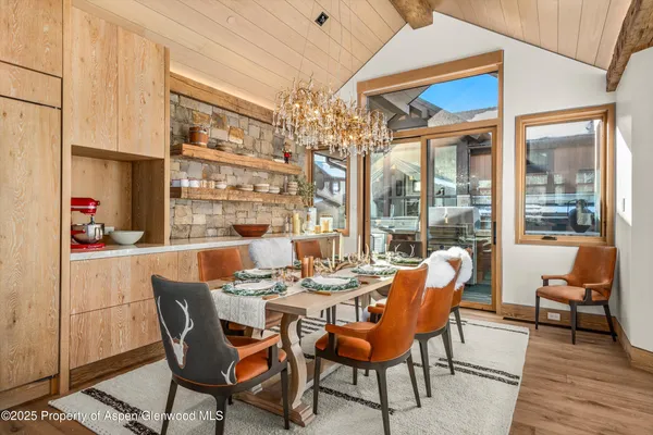 a dining room with furniture a chandelier and wooden floor