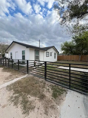 a view of house with yard and wooden fence