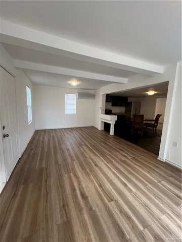 a view of a room with wooden floor and furniture