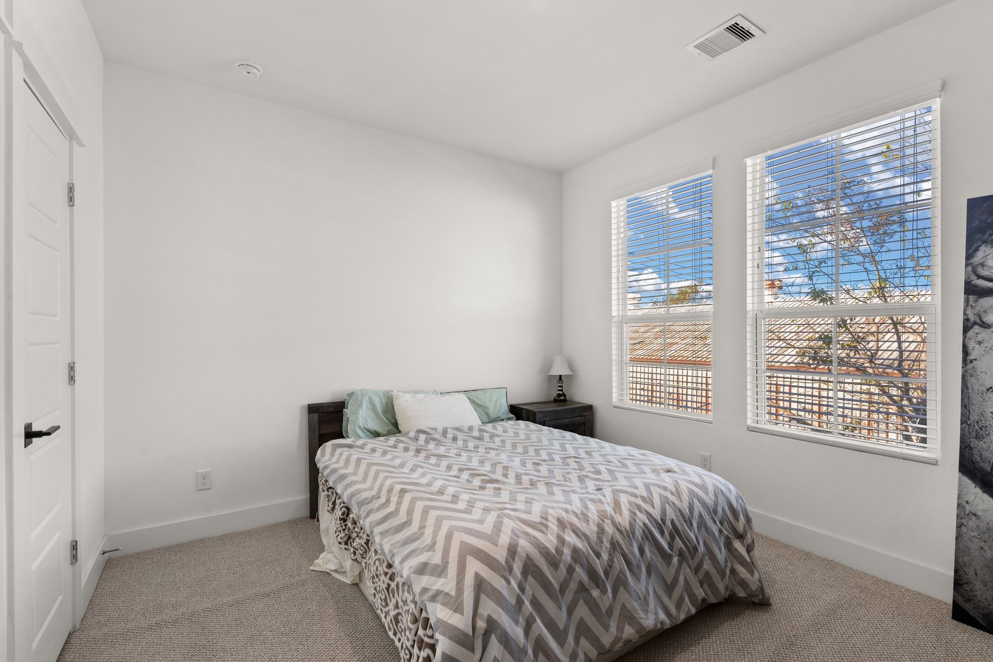2928 Stevens Street Houston, TX 77026 - Photo 19 of 30 This bedroom features a cozy layout with neutral walls, a bed, and natural light from two large windows, creating a bright and inviting atmosphere.