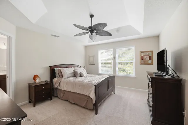 a bedroom with a bed and a flat tv screen on the dresser