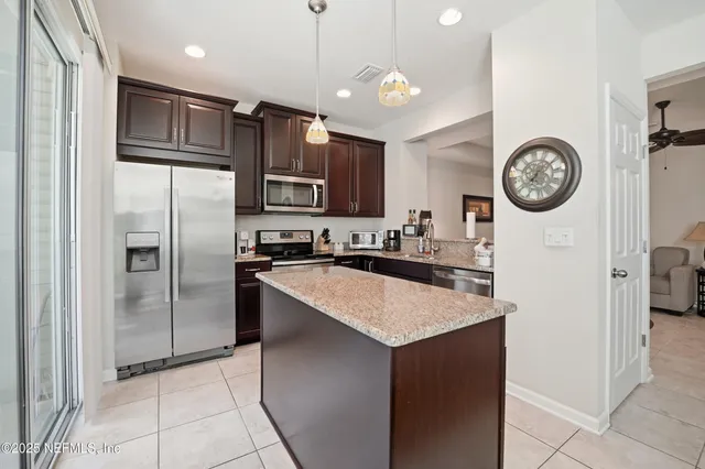 a kitchen with stainless steel appliances granite countertop a refrigerator a stove a sink and a refrigerator with wooden floor