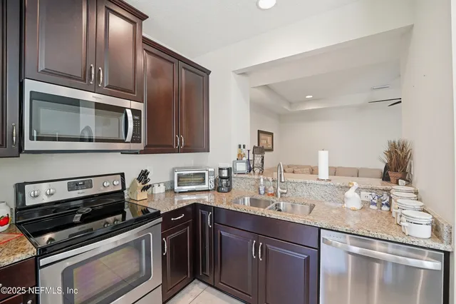 a kitchen with stainless steel appliances granite countertop a stove microwave and sink