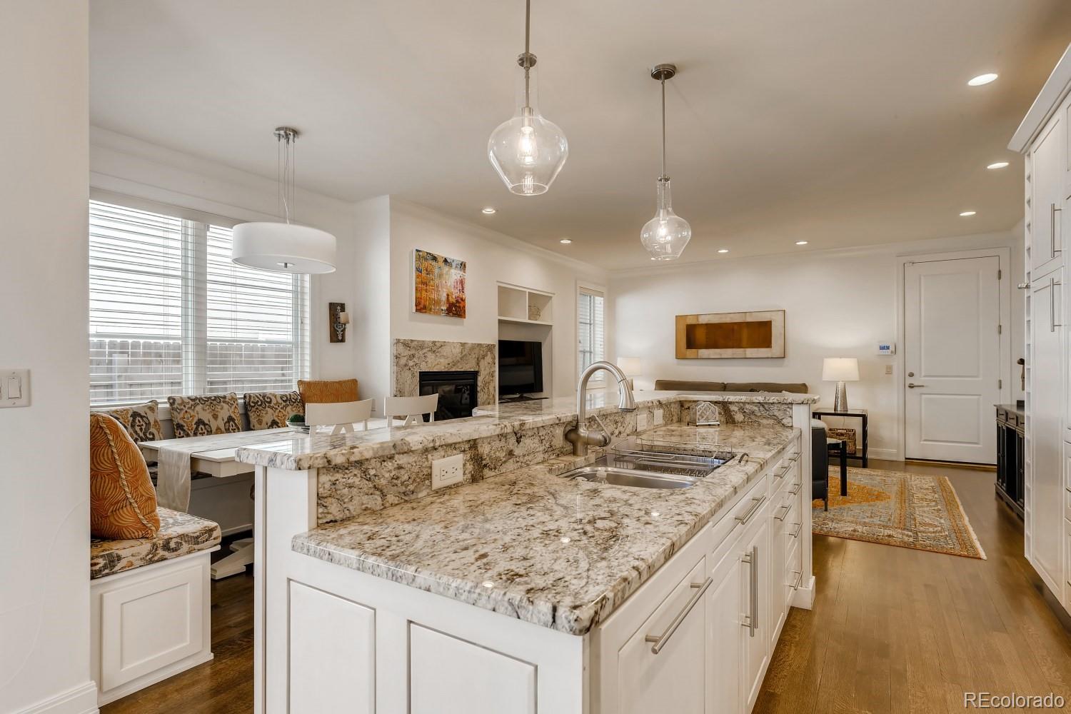 436 Jackson Street Denver, CO 80206 - Photo 14 of 40 a kitchen with kitchen island granite countertop a stove oven and a sink with cabinets