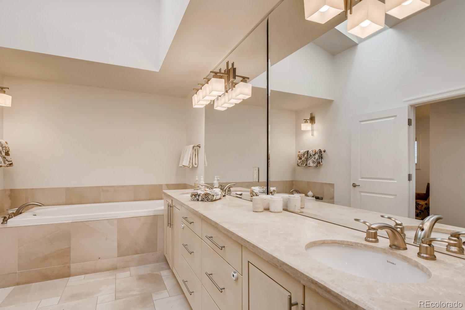 436 Jackson Street Denver, CO 80206 - Photo 23 of 40 a bathroom with a double vanity sink a mirror and a bathtub