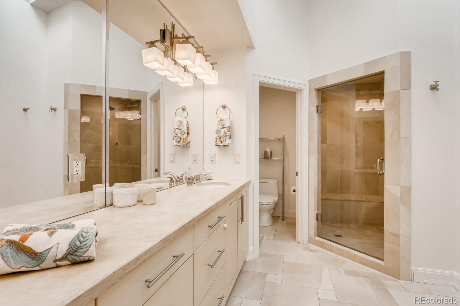 436 Jackson Street Denver, CO 80206 - Photo 24 of 40 a spacious bathroom with a granite countertop sink a mirror and shower