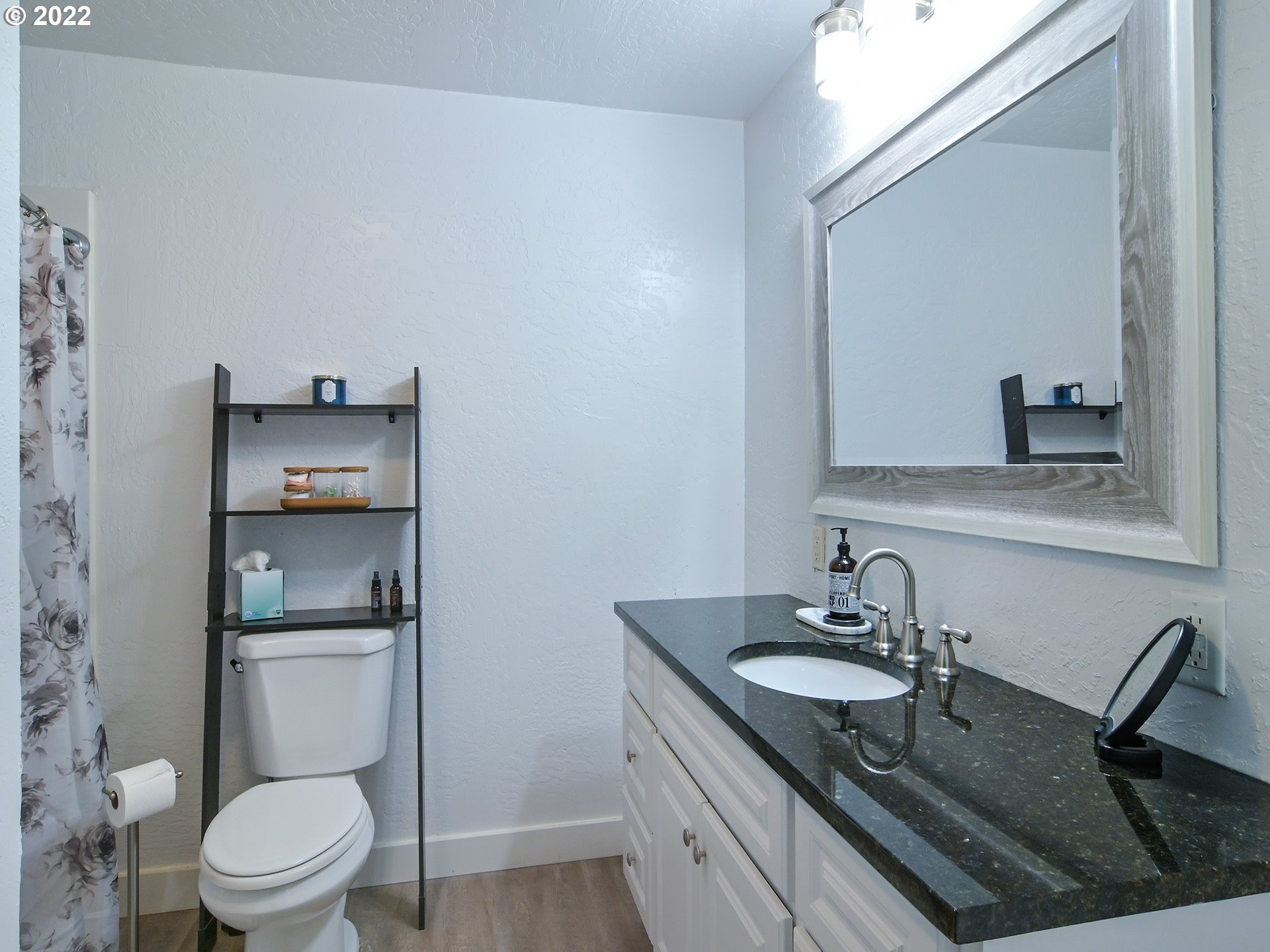 1704 H Street Springfield, OR 97477 - Photo 22 of 30 a bathroom with a granite countertop toilet sink and mirror