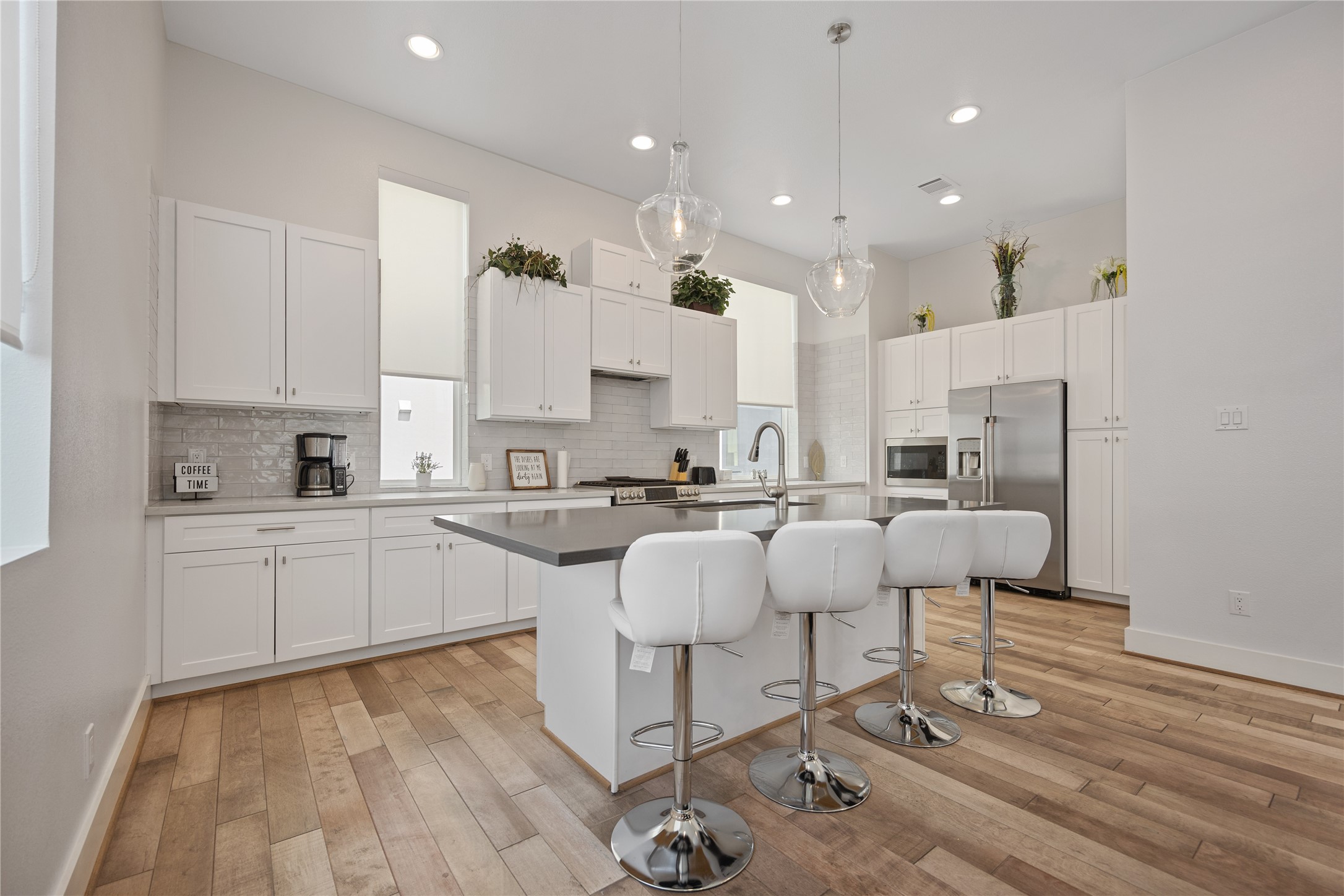 5914 Val Verde Street Houston, TX 77057 - Photo 7 of 25 a large white kitchen with cabinets a sink a stove a dining table and chairs