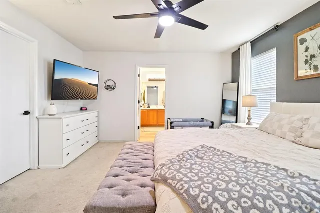 a bedroom with a bed a flat screen tv and a chandelier