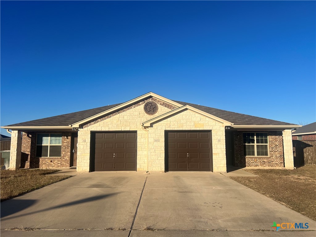 1401 Loyal Lane, Unit B Killeen, TX 76549 - Photo 2 of 24 a front view of a house with a garage and a yard