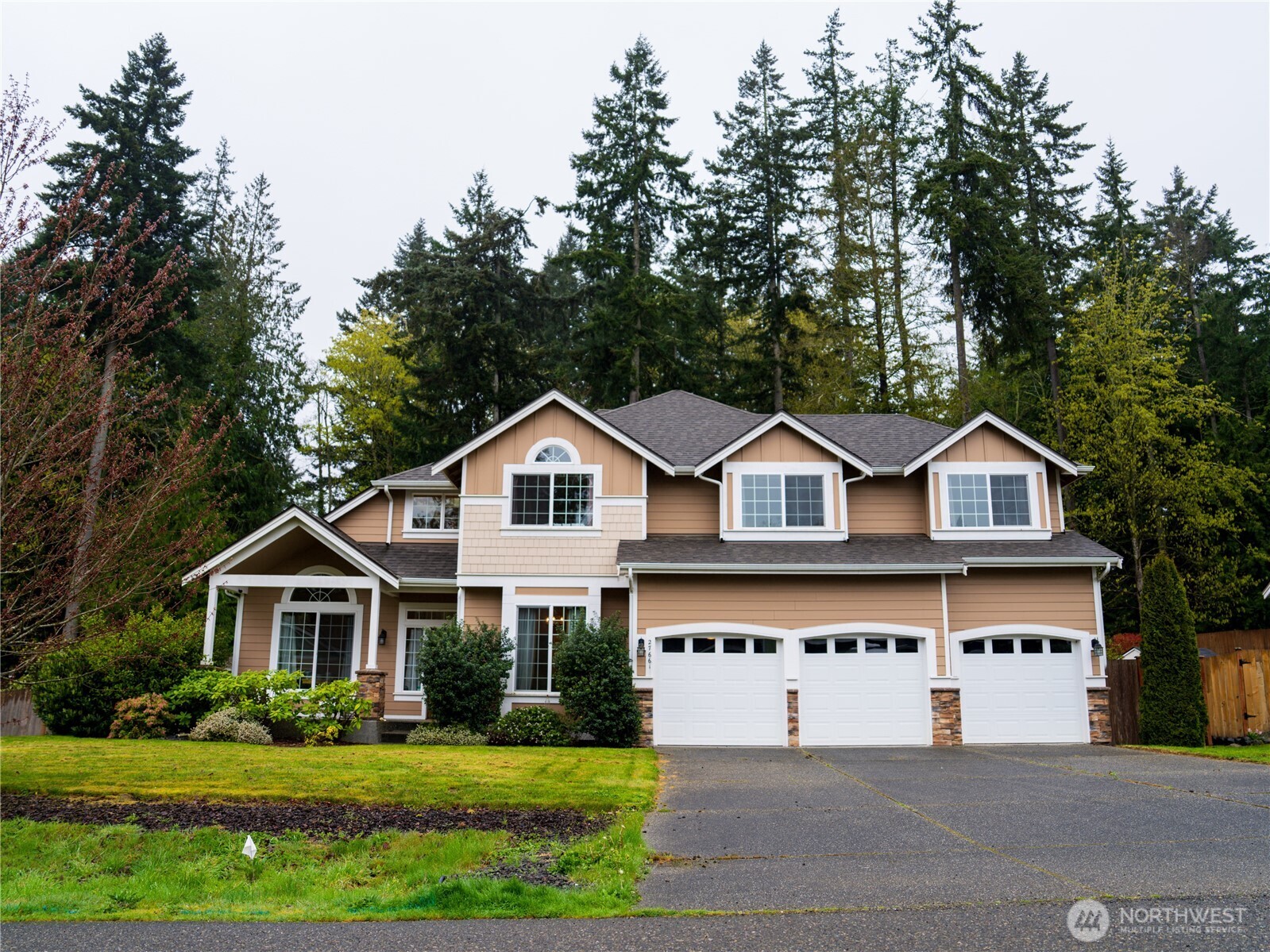 27661 McIntosh Loop Northeast Kingston, WA 98346 - Photo 1 of 34 a front view of a house with a garden and trees