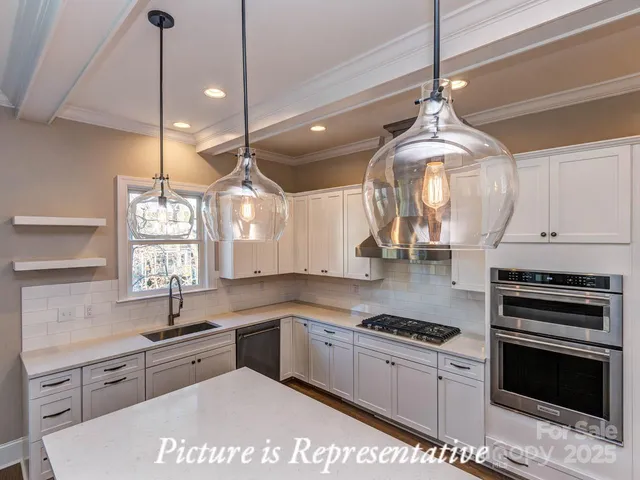 a kitchen with stainless steel appliances granite countertop a sink a stove and cabinets