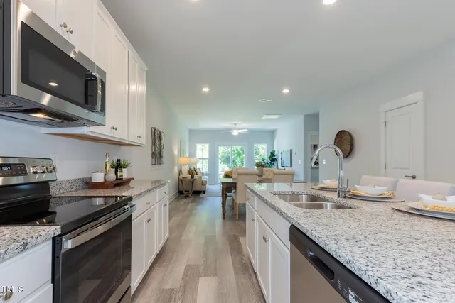 a kitchen with a sink a stove a refrigerator and cabinets