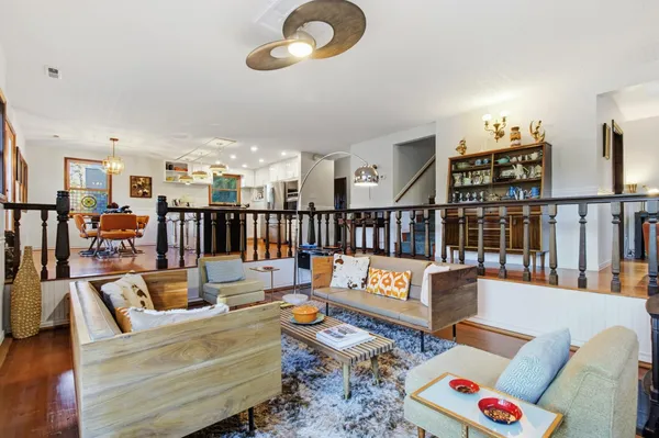 a view of a dining room with furniture a chandelier and wooden floor