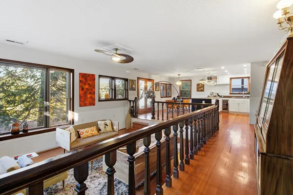 a kitchen with stainless steel appliances granite countertop a stove top oven a refrigerator a dining table and chairs with wooden floor