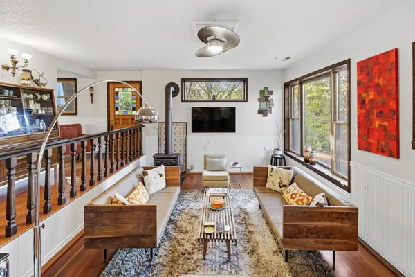 a living room with furniture a flat screen tv and a window