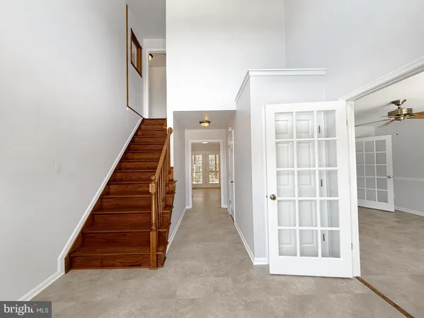 a view of an empty room with wooden floor fireplace and a window