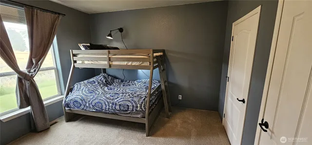 a bed sitting in a bedroom next to a window