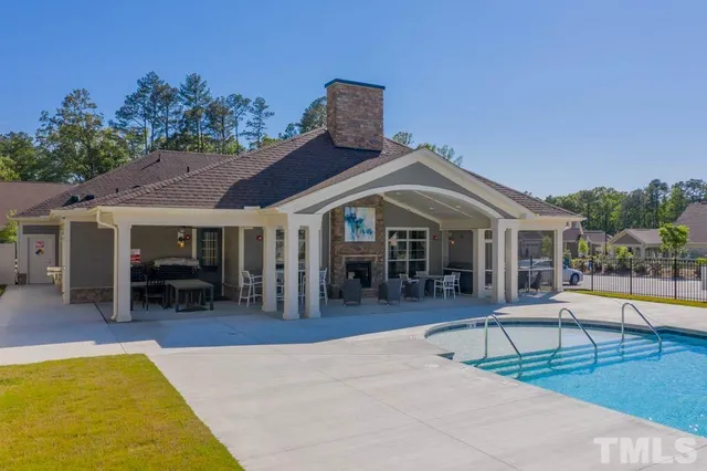 a view of a house with swimming pool and sitting area