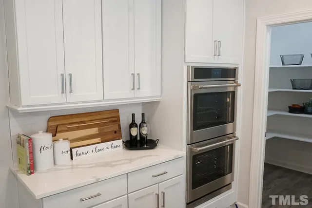 a kitchen with white cabinets and appliances