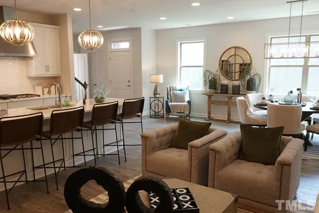 a living room with furniture a large window and dining table