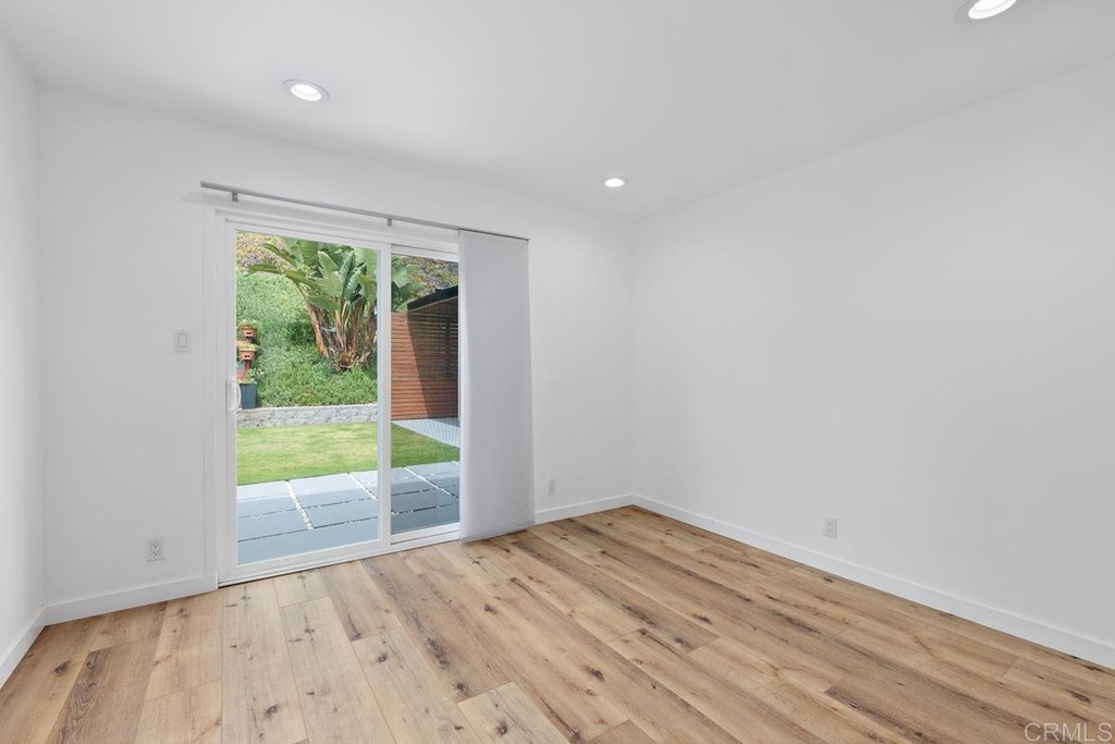 742 Snapdragon Street Encinitas, CA 92024 - Photo 12 of 22 a view of an empty room with wooden floor and a window