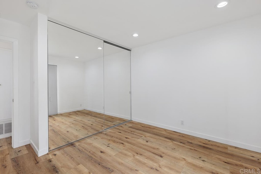 742 Snapdragon Street Encinitas, CA 92024 - Photo 14 of 22 an empty room with wooden floor and cabinet