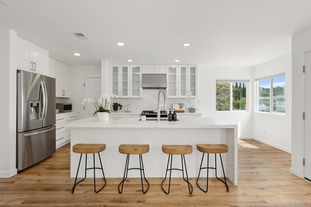742 Snapdragon Street Encinitas, CA 92024 - Photo 4 of 22 a kitchen with stainless steel appliances kitchen island granite countertop a refrigerator a stove a sink and chairs