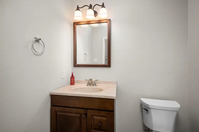 a bathroom with a toilet sink and mirror