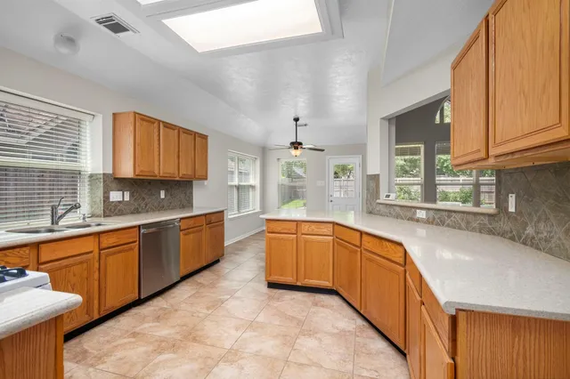 a large kitchen with stainless steel appliances granite countertop a sink and cabinets