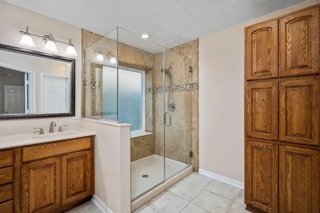 a bathroom with a shower sink and mirror
