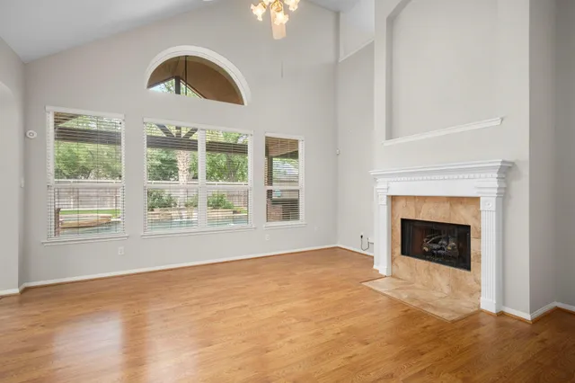 a view of an empty room with a fireplace and a window