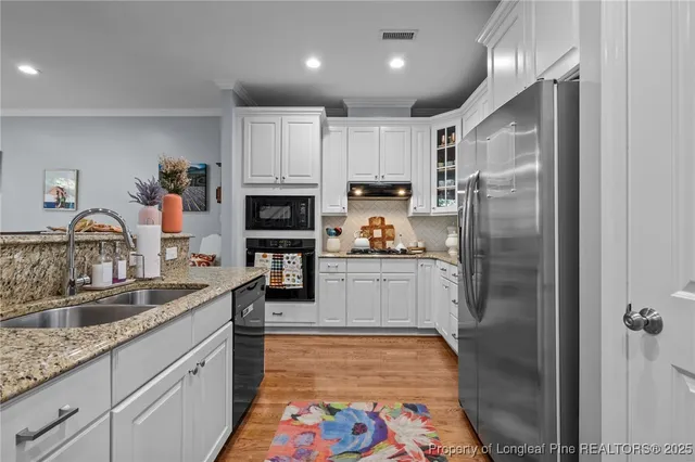 a kitchen with granite countertop cabinets stainless steel appliances and wooden floor