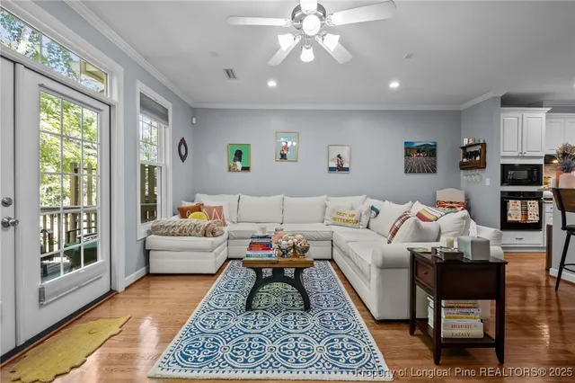 a living room with furniture a flat screen tv and a fireplace