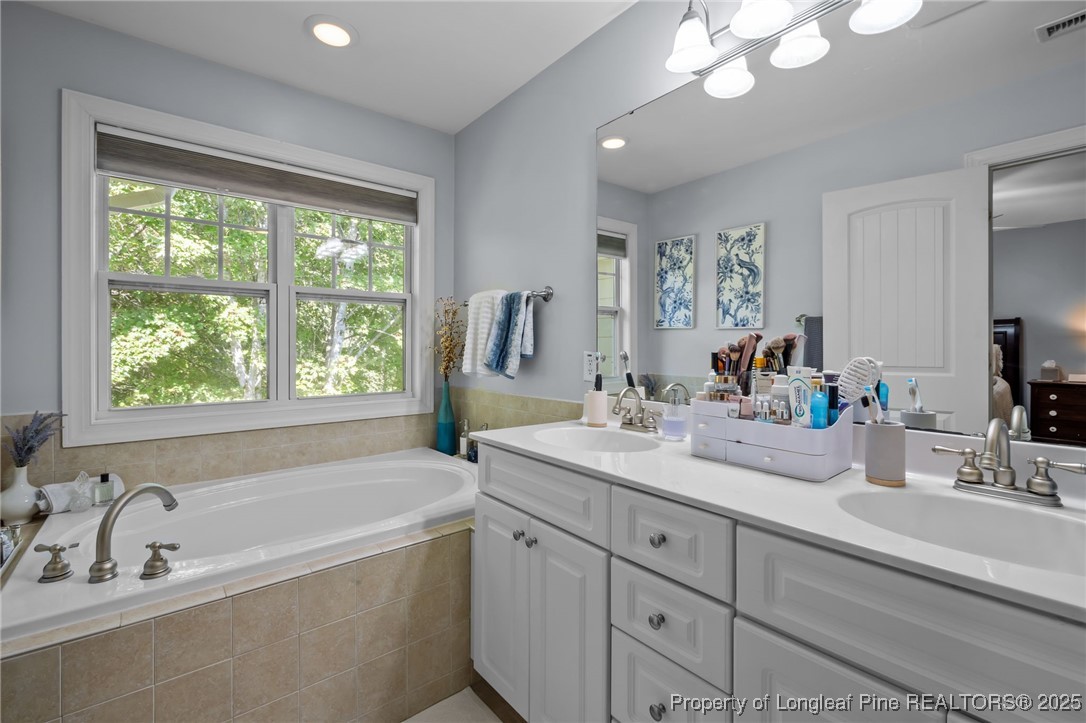47 Abernathy Drive, Unit 13 Chapel Hill, NC 27517 - Photo 24 of 46 a bathroom with a tub a sink a large mirror and vanity