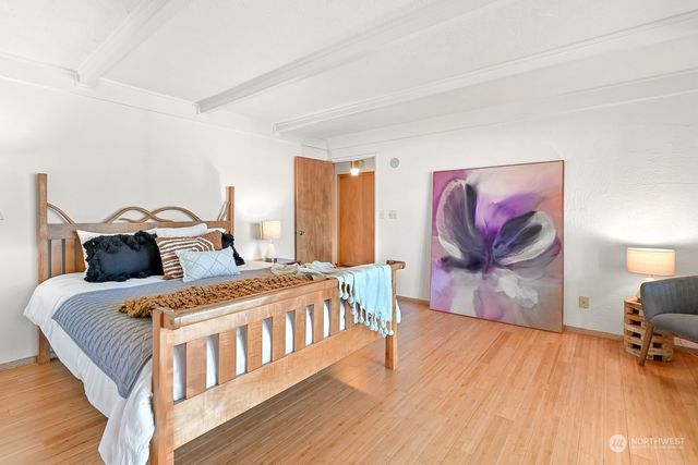 a bedroom with a bed and wooden floor